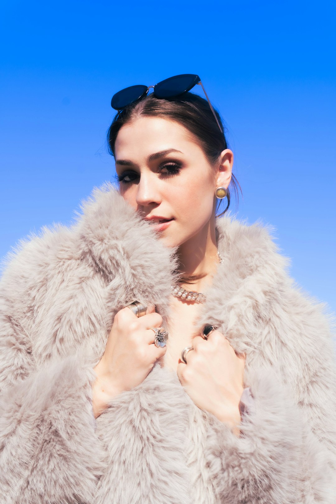 woman-in-fluffy-coat-against-blue-sky-te0avirptfq