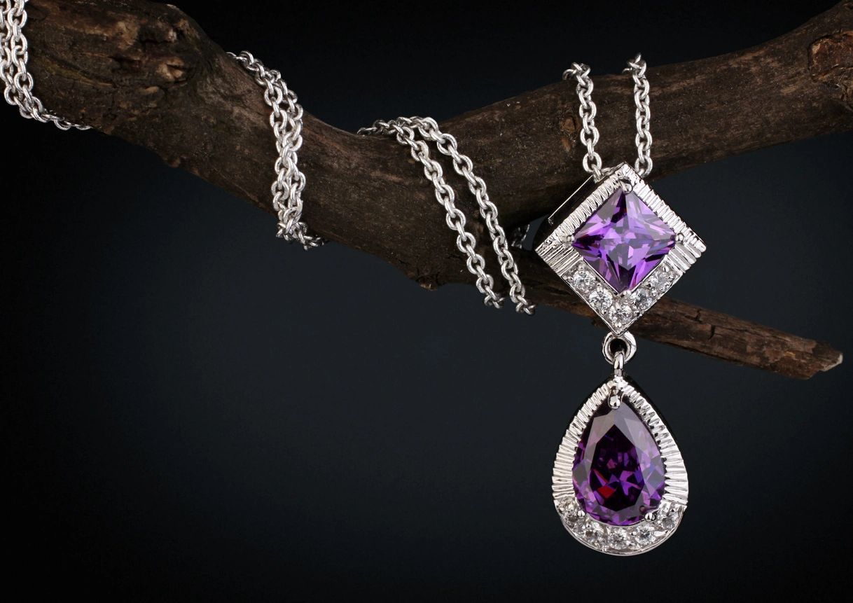 jewelry pendant witht gem amethyst on twig, black background